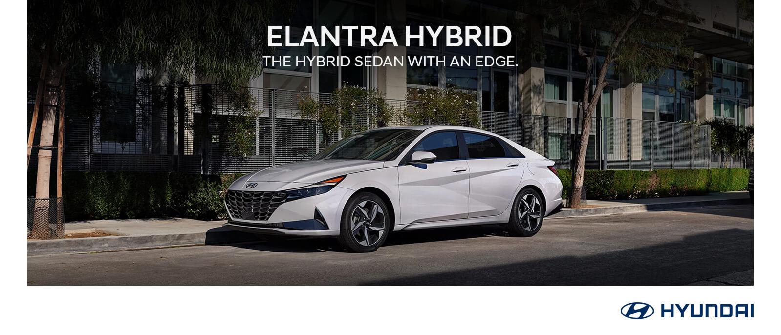 2023 White Hyundai Elantra Hybrid parked near a building.