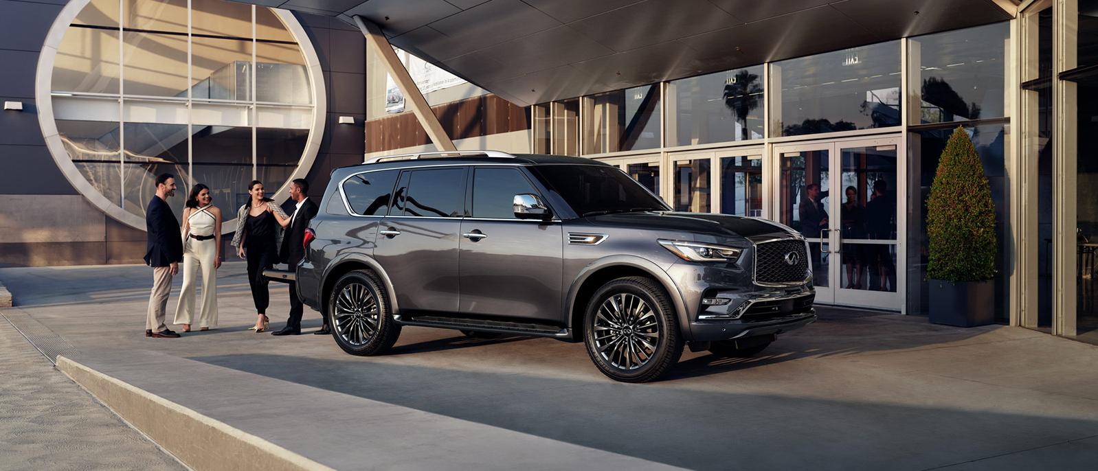 Graphite Shadow INFINITI QX80 parked outside a glass building