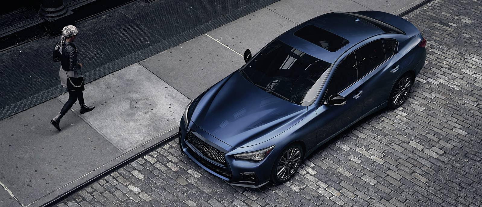INFINITI Q50 Parked Outside on brick road with someone walking by