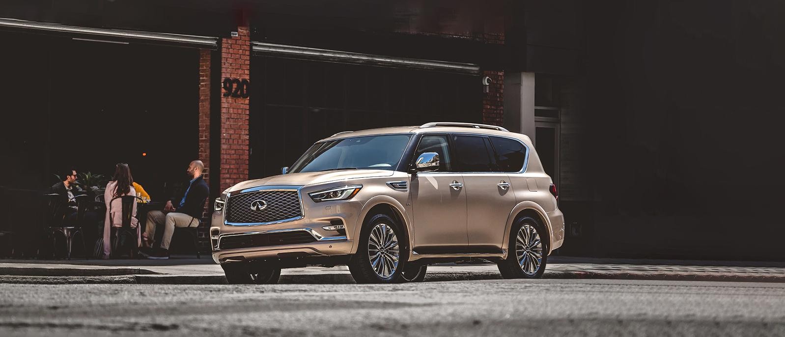 A QX80 champagne quartz Parked in front of a Restaurant