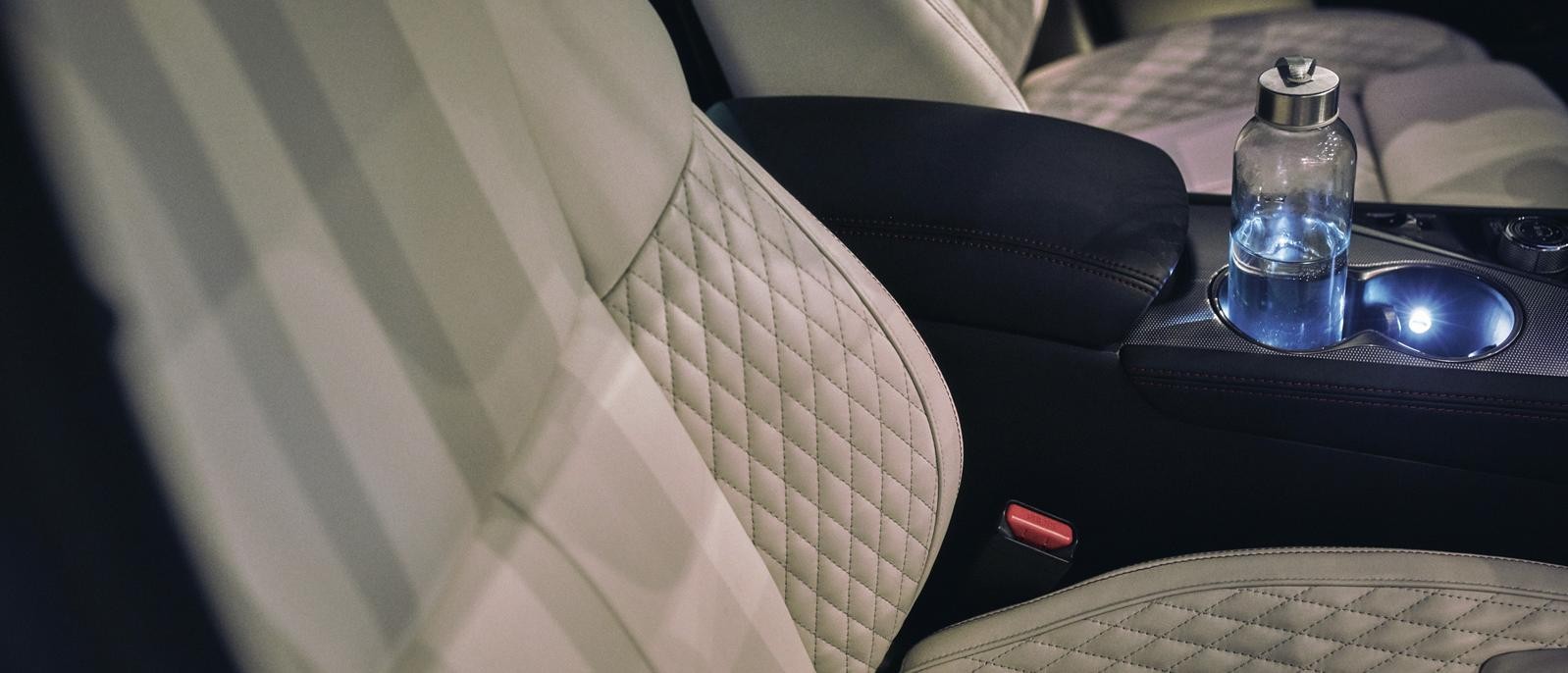 Close up interior image of INFINITI Q50 with water bottle in cup holder