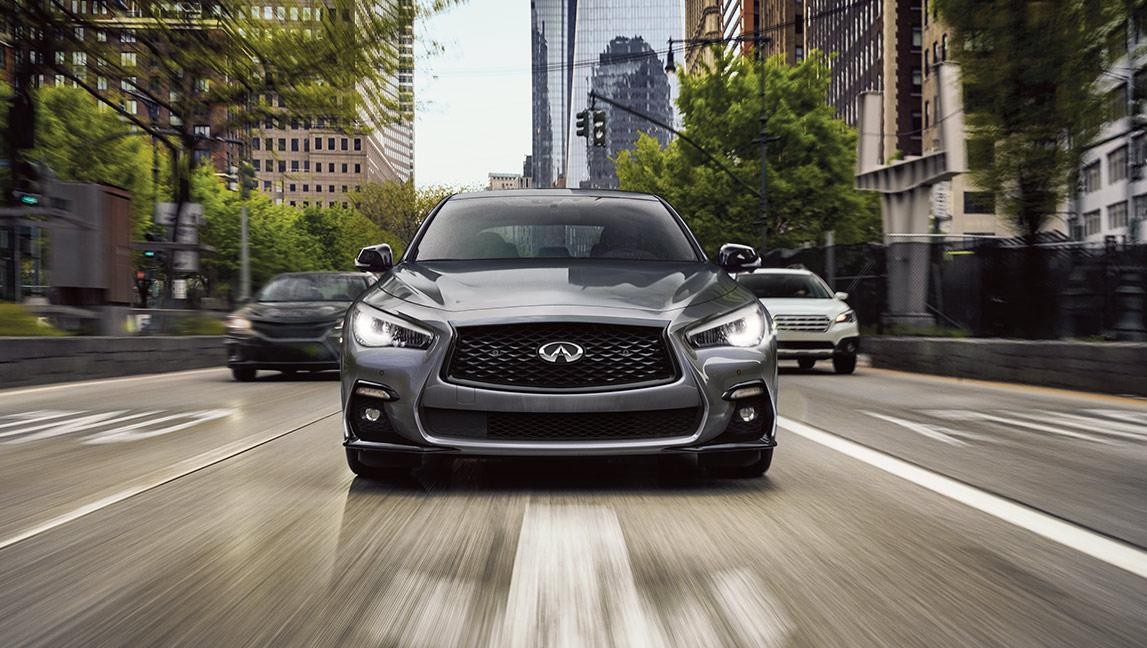 Grey INFINITI Q50 driving on a road.