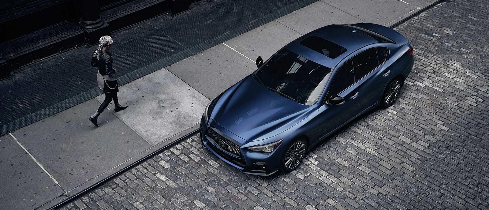 INFINITI Q50 Parked Outside on brick road with someone walking by