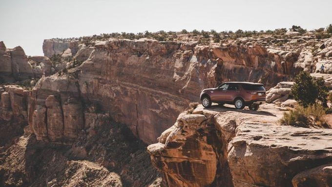 Land Rover vehicle parked beside cliff