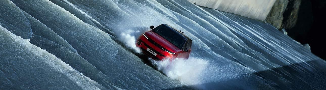 Red Range Rover cruising through the water.