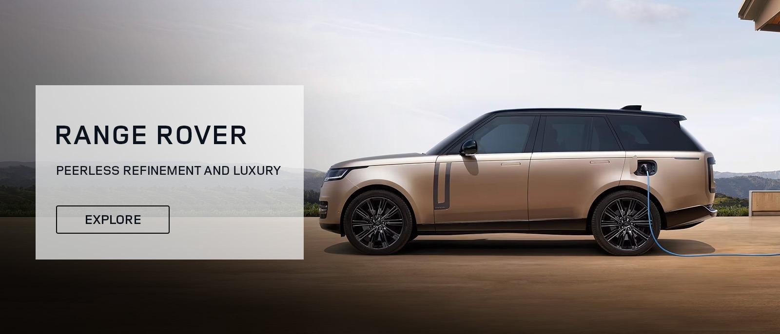 A bronze Land Rover Range Rover parked on the driveway of a modern home.