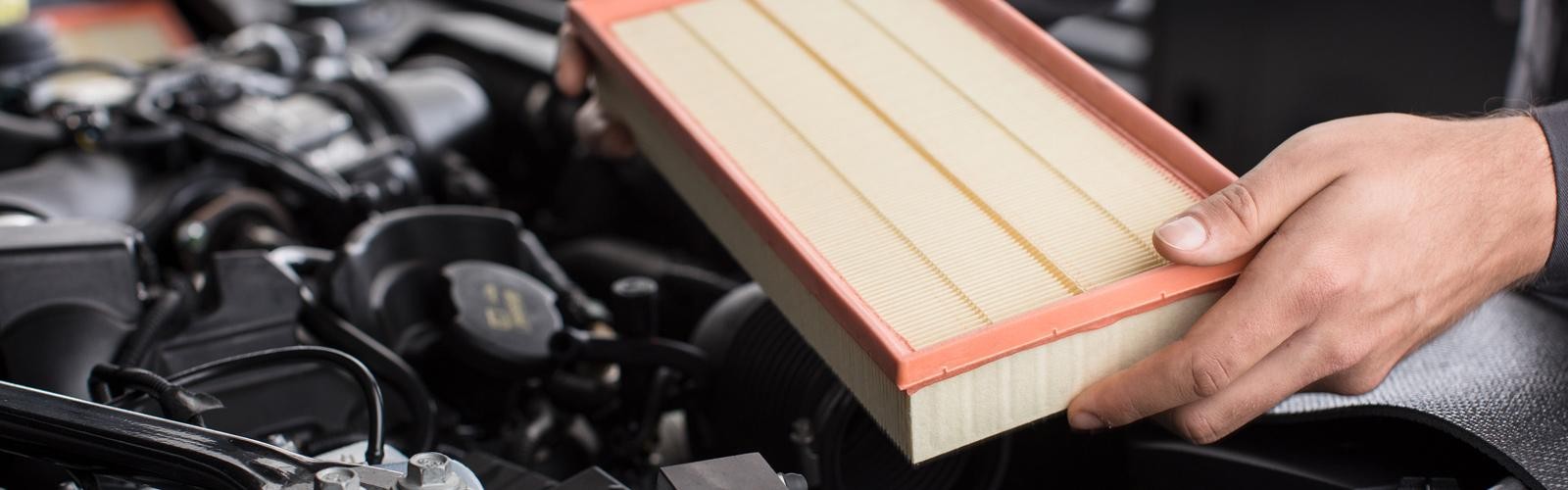 A Land Rover service technician installing a new air filter.