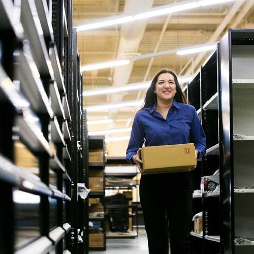 Woman carrying box through parts department