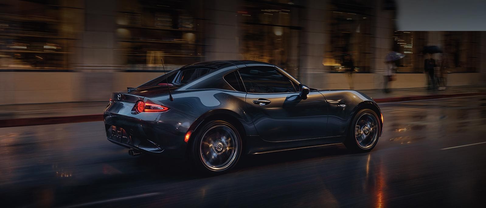 A 2022 Mazda MX 5 Miata RF driving on the road.