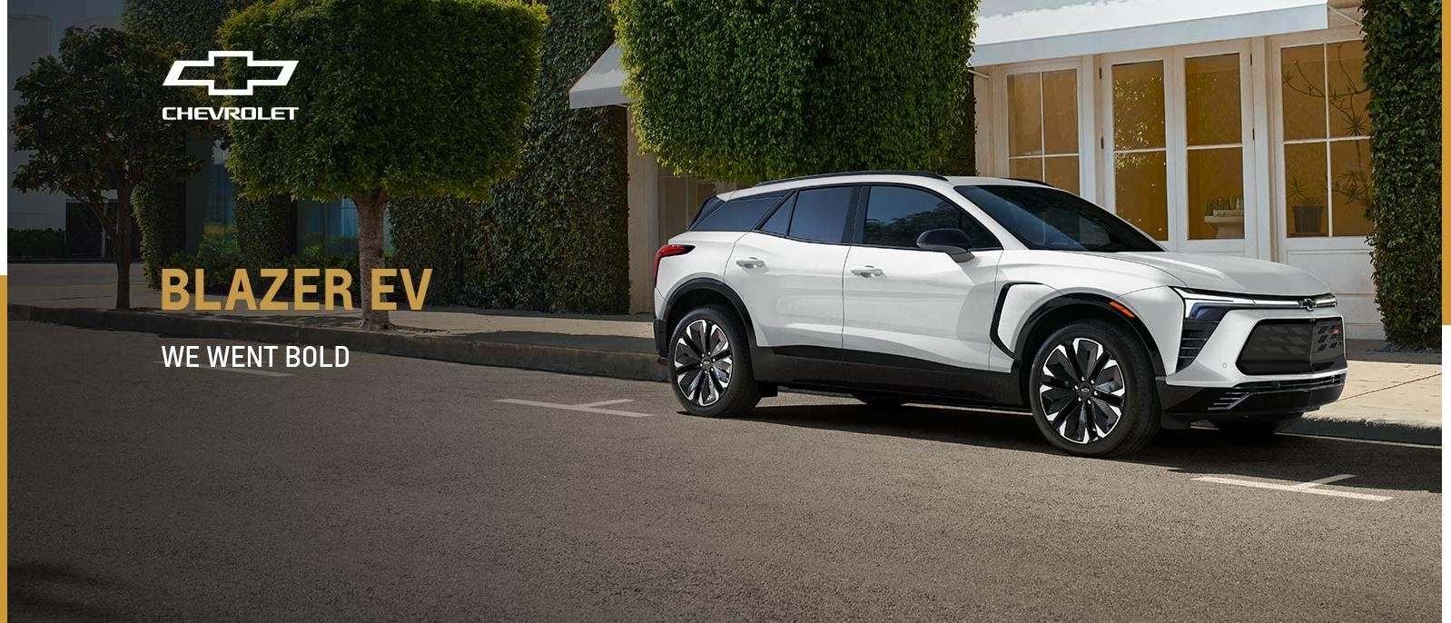 White 2024 Chevrolet Blazer EV is parked at roadside.