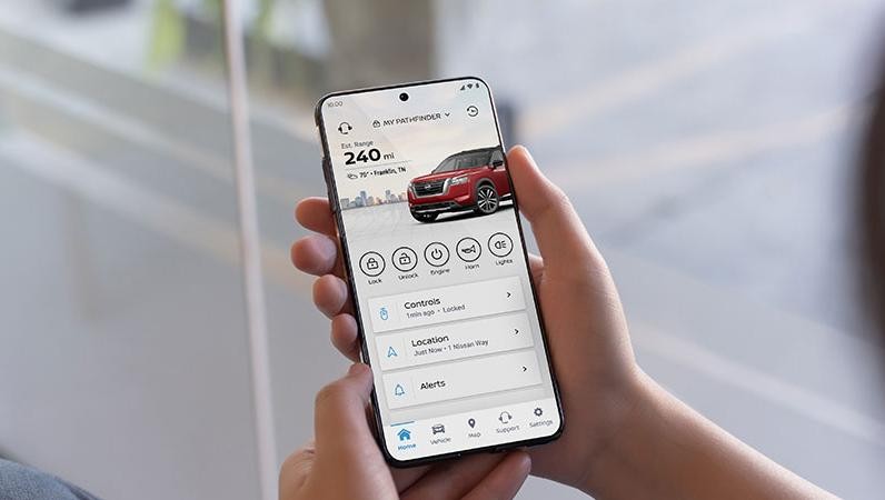Person holding a smartphone with the MyNissan app
