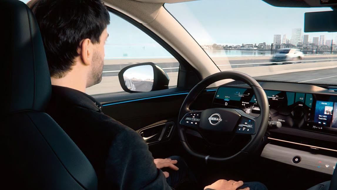 Man sitting in driver's seat of Nissan EV.