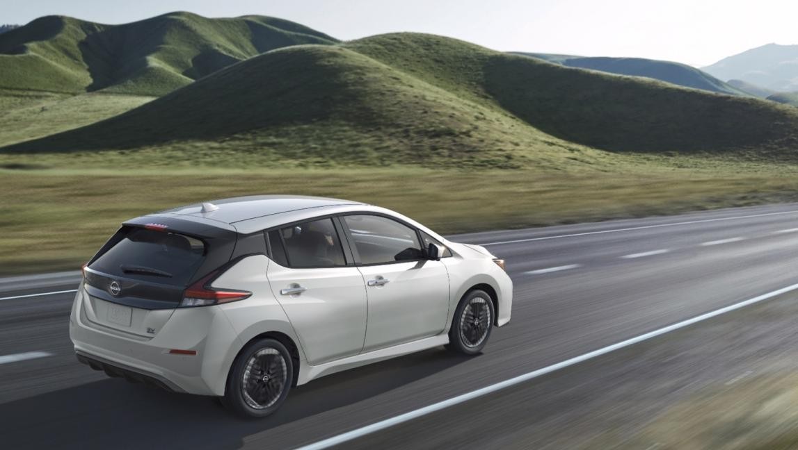 Nissan LEAF on road in front of green hills