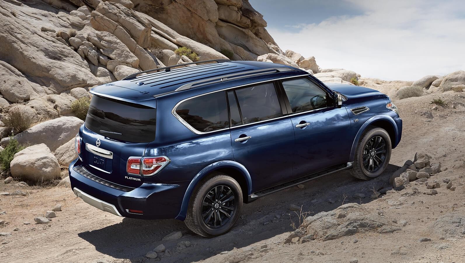 Blue 2023 Nissan Armada driving on terrain.