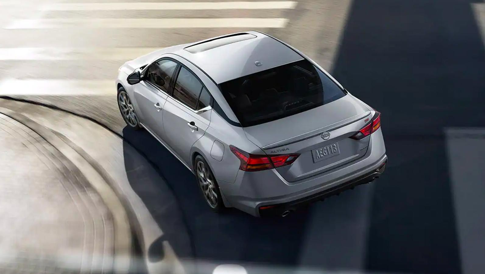 White 2023 Nissan Altima top rear view while cruising on the road.