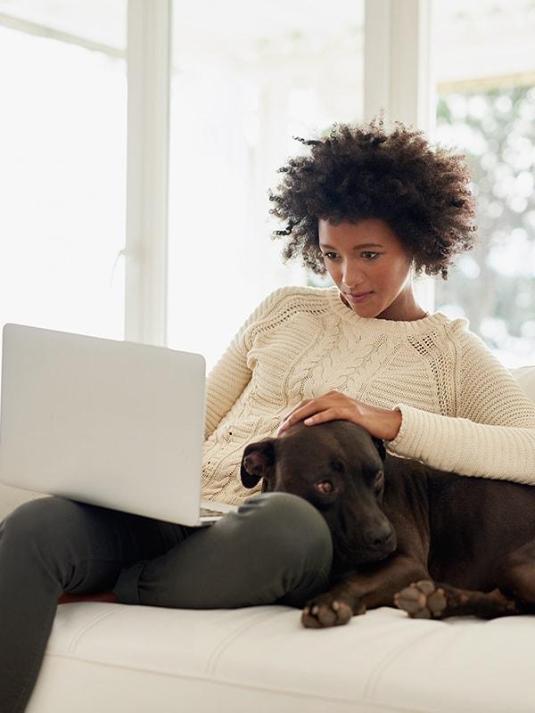 Woman using a laptop computer with her dog