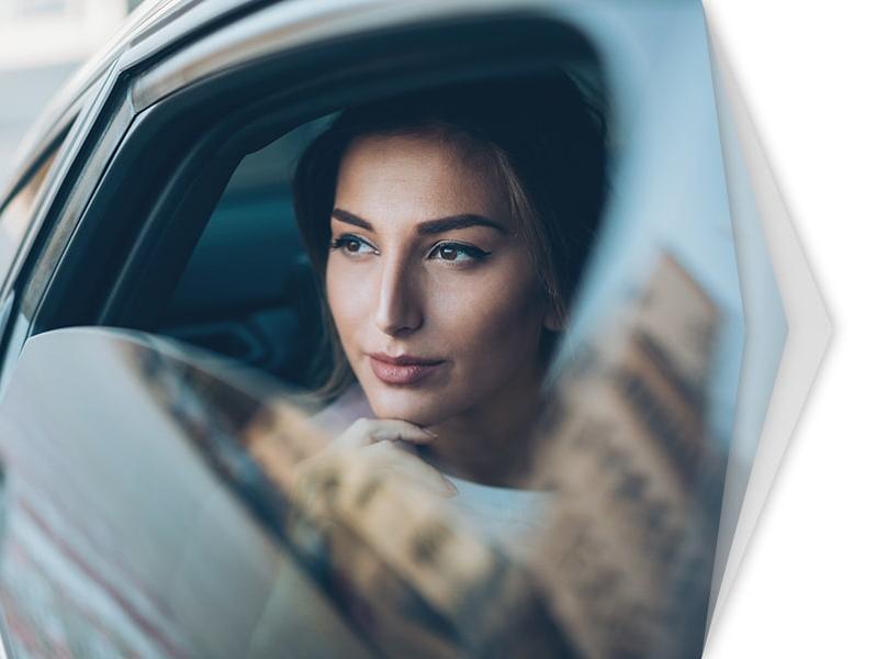 Woman sitting in a car looking out the window