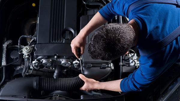 Service technician working on a vehicle engine