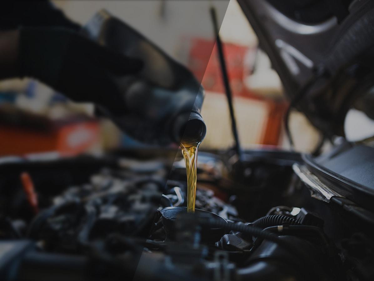 Mechanic adding oil to a vehicle's engine