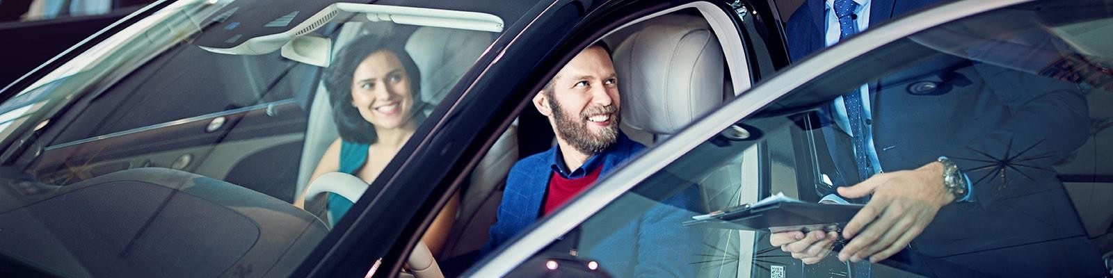 Customers testing a new car in a dealership