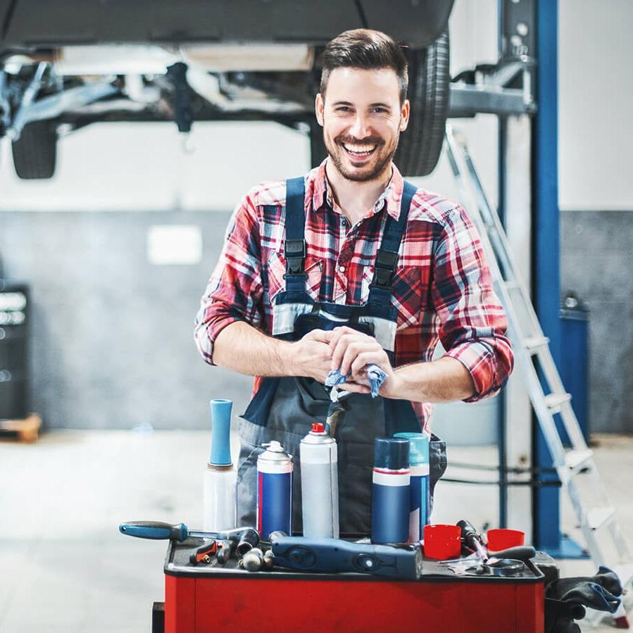 Smiling mechanic in a service garage