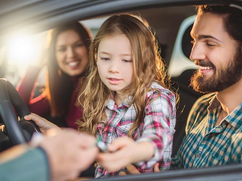 Family in a new car in a dealership