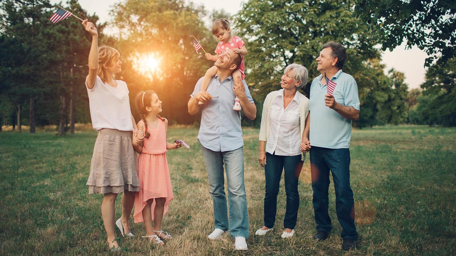 Family in a park holding American flags