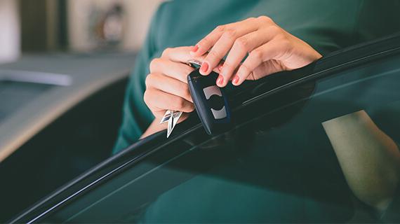 Woman holding keys to a new car.