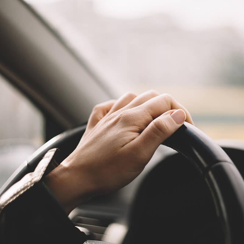 Woman's hand on a vehicle steering wheel