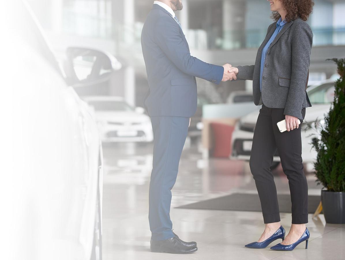 Dealership associate shaking hands with a customer