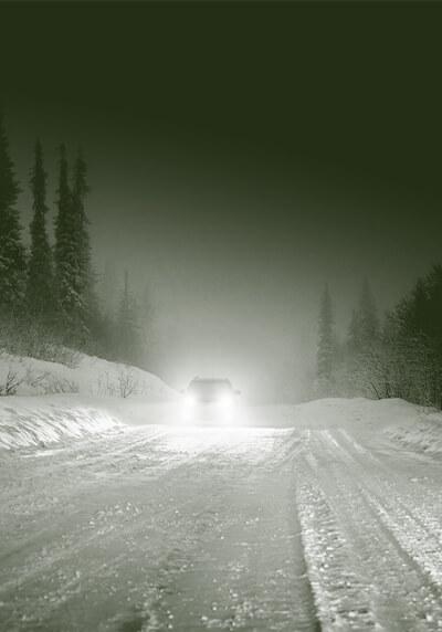 Car driving in the snow at night