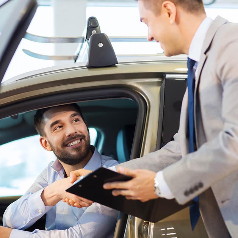 Customer shaking hands with a dealership sales associate