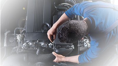 Service mechanic working on a vehicle engine