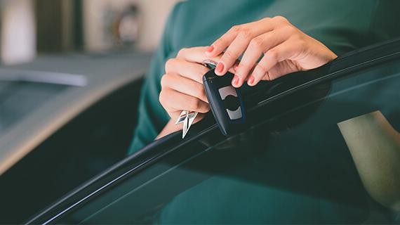 Woman holding keys to a new car.