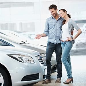 Couple looking at new cars in a dealership