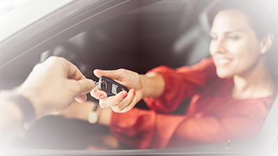 Woman in a dealership receiving her new car keys