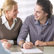 Young couple signing finance documents