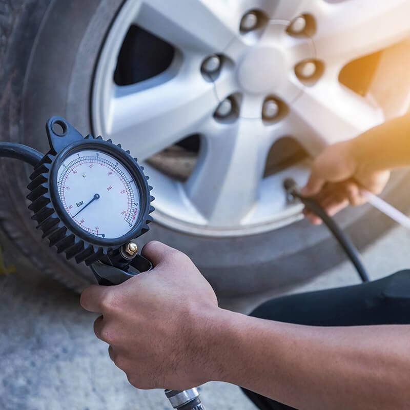 Mechanic checking the pressure on a tire