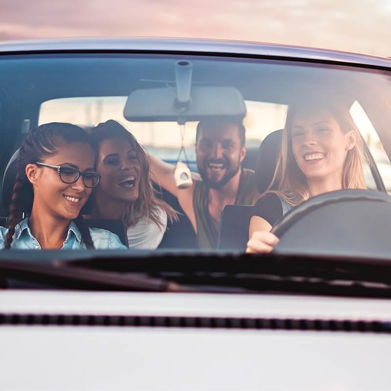 Young friends driving in a car