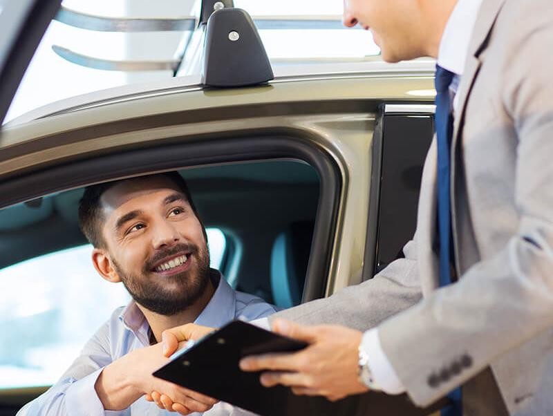 Customer shaking hands with a dealership sales associate