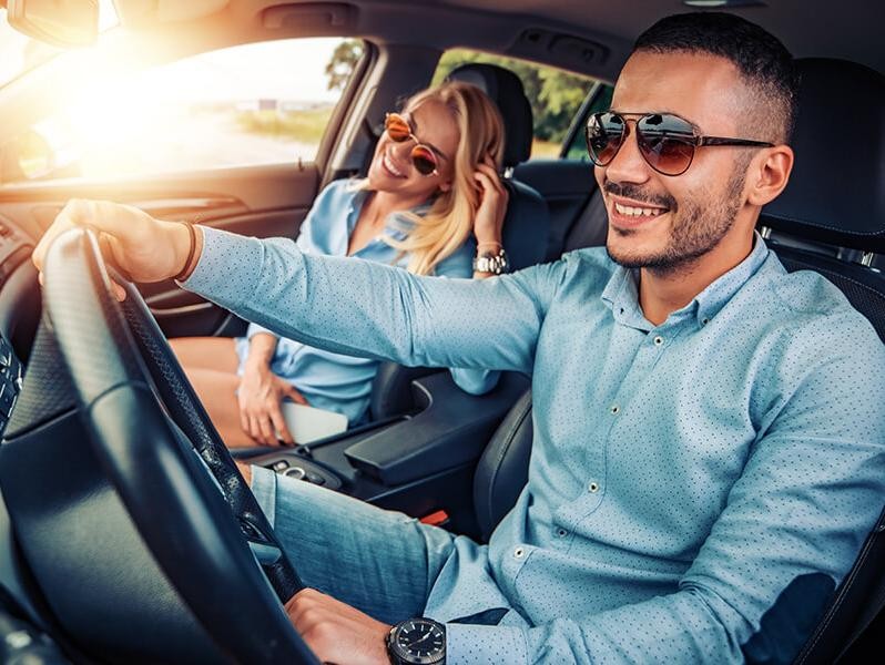 Happy couple driving in their car