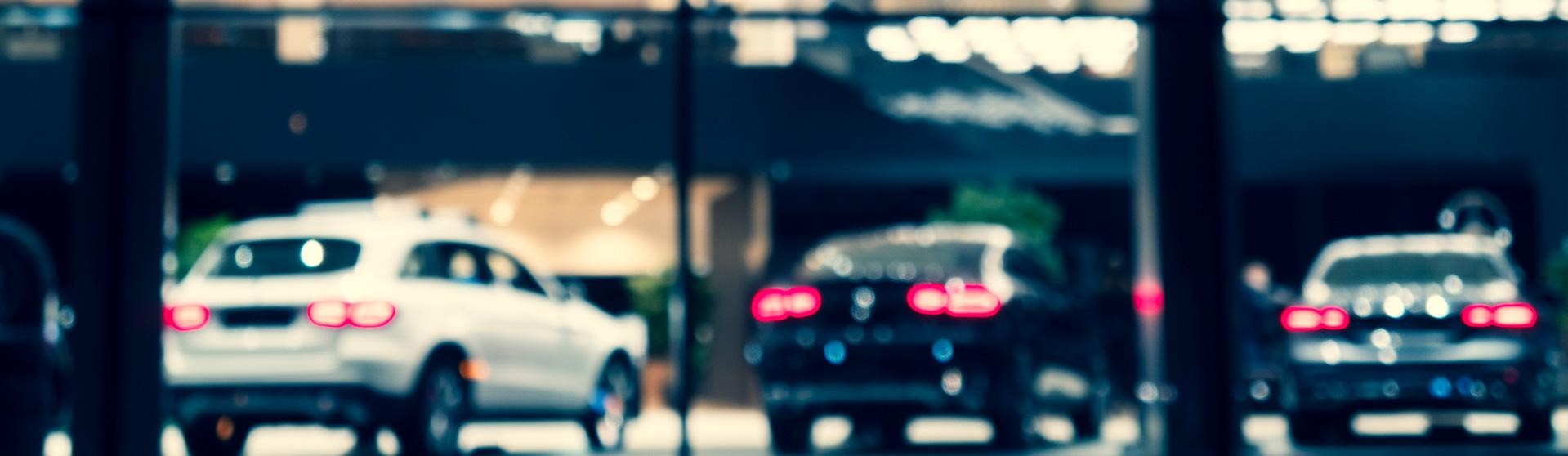 Blurred background with car dealership exterior