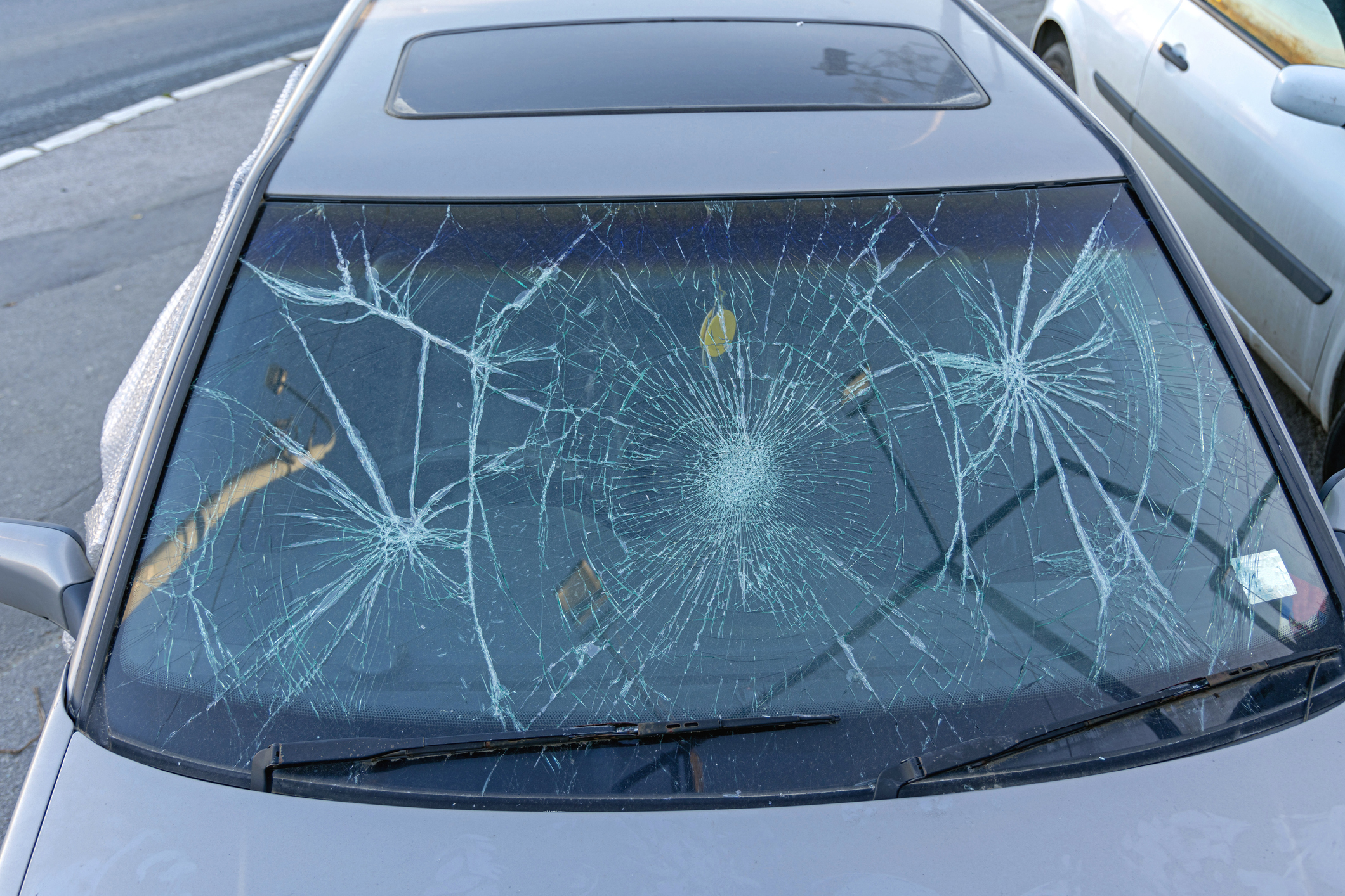 A series of windshield cracks on a vehicle. 