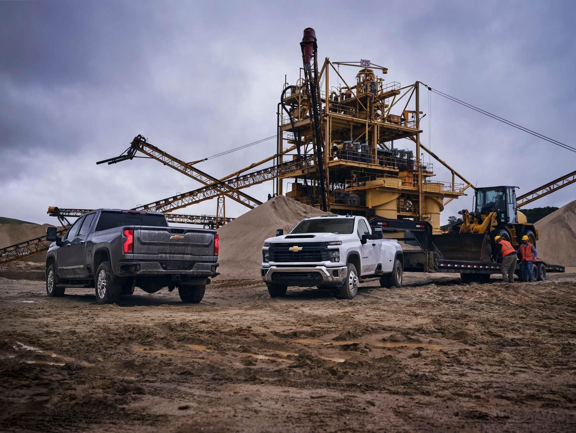 A group of Chevy work trucks at a job site.