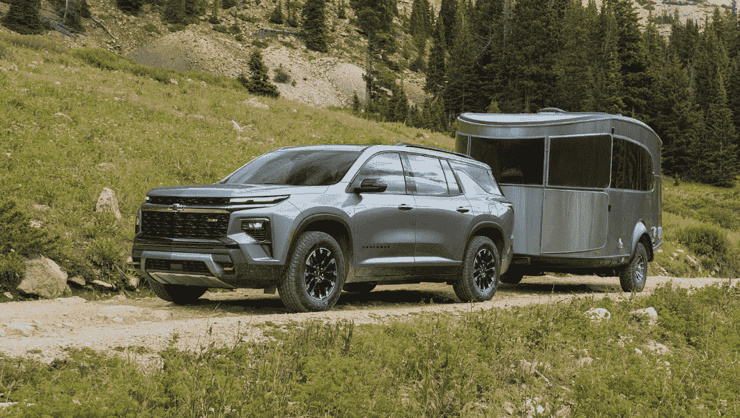 A Chevy Traverse SUV tows a trailer behind it.