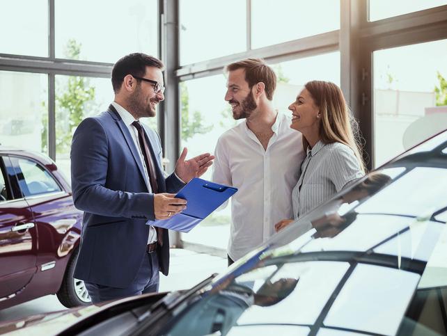 Woman Chatting with Salesperson in Dealership Showroom