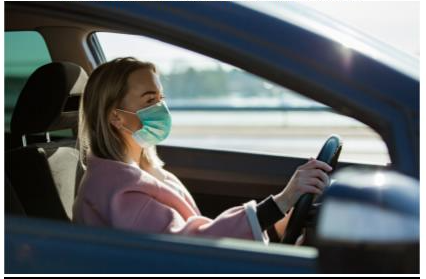Woman driving a car with a mask 