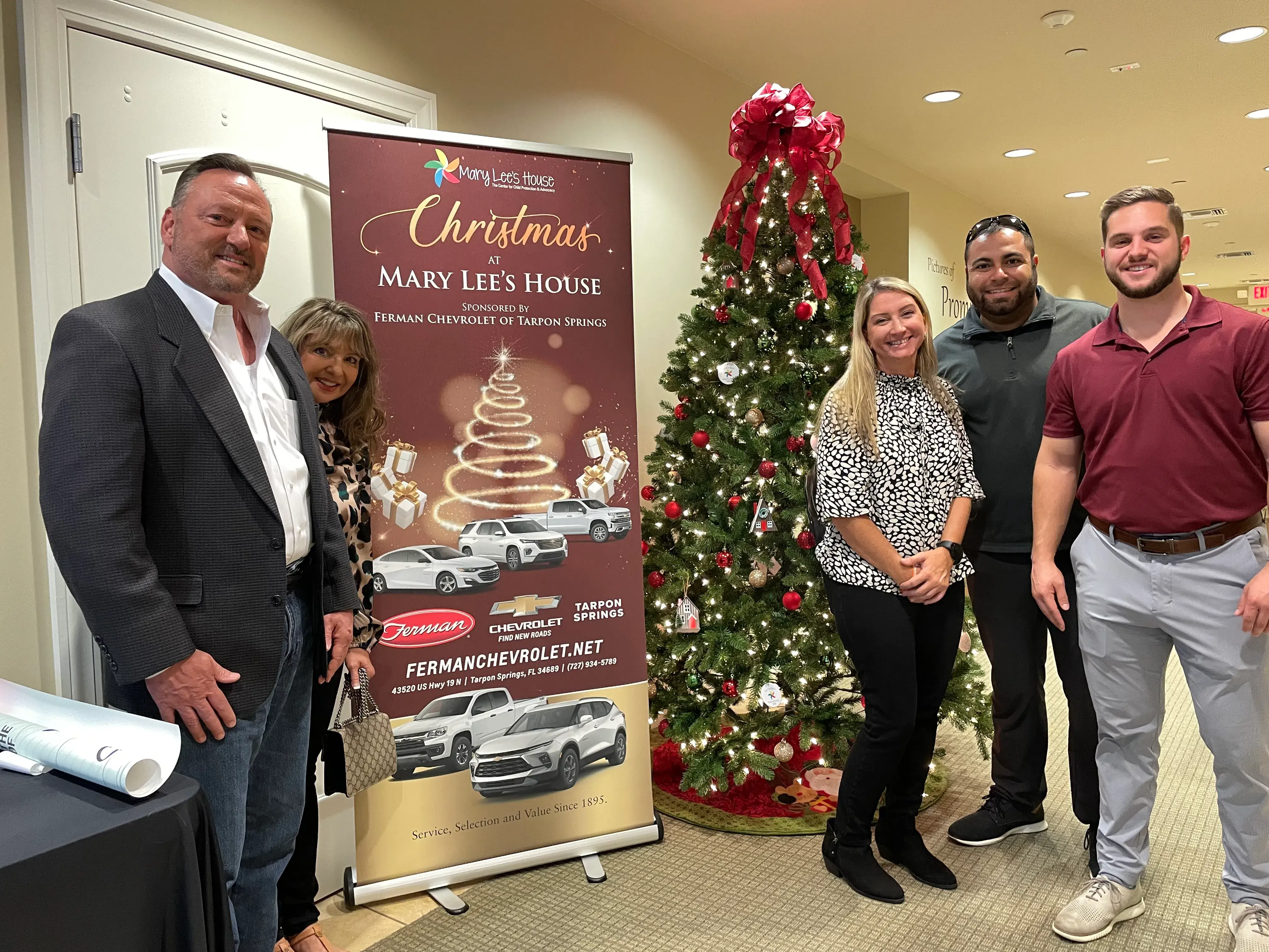 Ferman and Mary Lee Staff by Banner and Christmas Tree