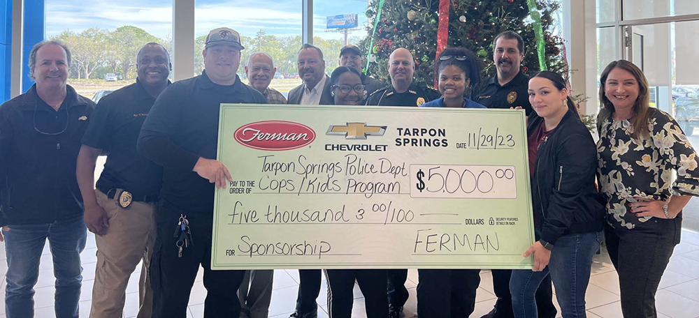 Ferman Chevrolet of Tarpon Springs Management handing sponsor check to Tarpon Springs Police Department for Cops N Kids program