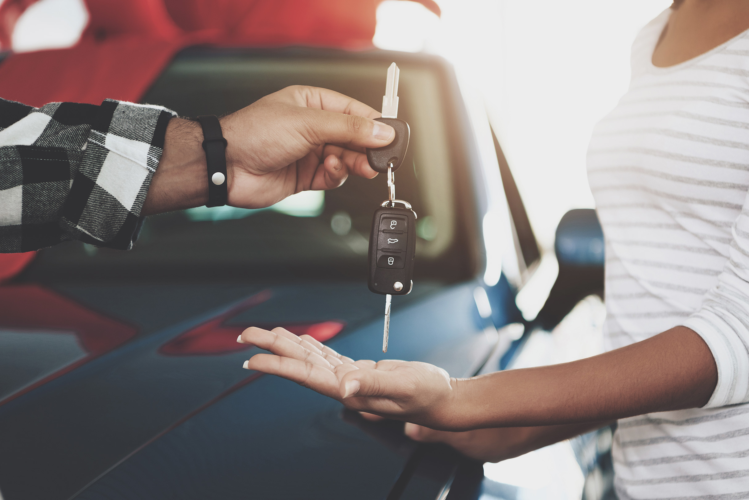 Woman in red taking her new car keys